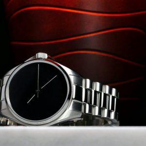 Orologio da polso da uomo di lusso con un elegante quadrante nero e un cinturino in argento lucido.